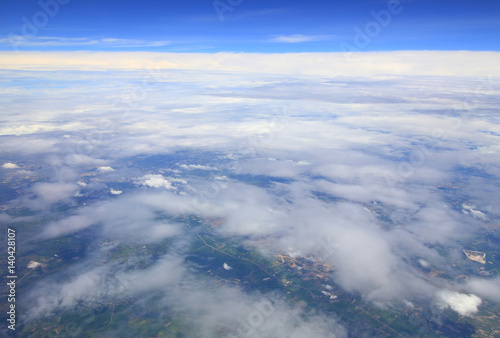 Aerial photo of land and clouds from above.