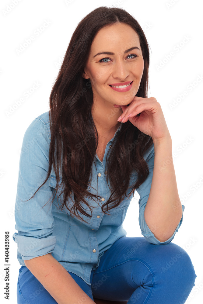 smiling casual woman sitting and thinking smiling casual woman sitting and thinking