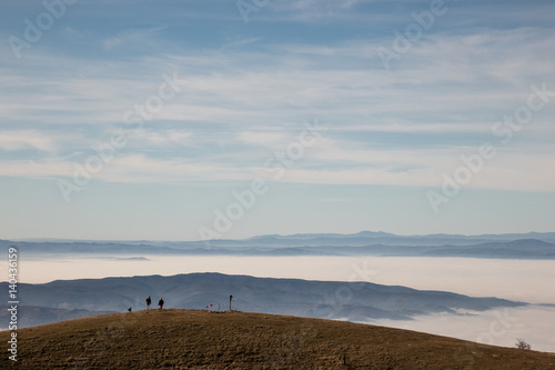 A couple on top of a mountain looking at a sea of fog