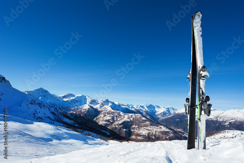 Ski stand in snow bank with mountain on background © Sergey Novikov