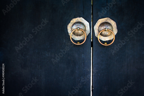 Old lockpad locked on a wooden blue door with rusty chain close up background. photo