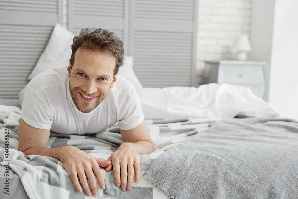 Carefree guy resting in bedroom Carefree guy resting in bedroom