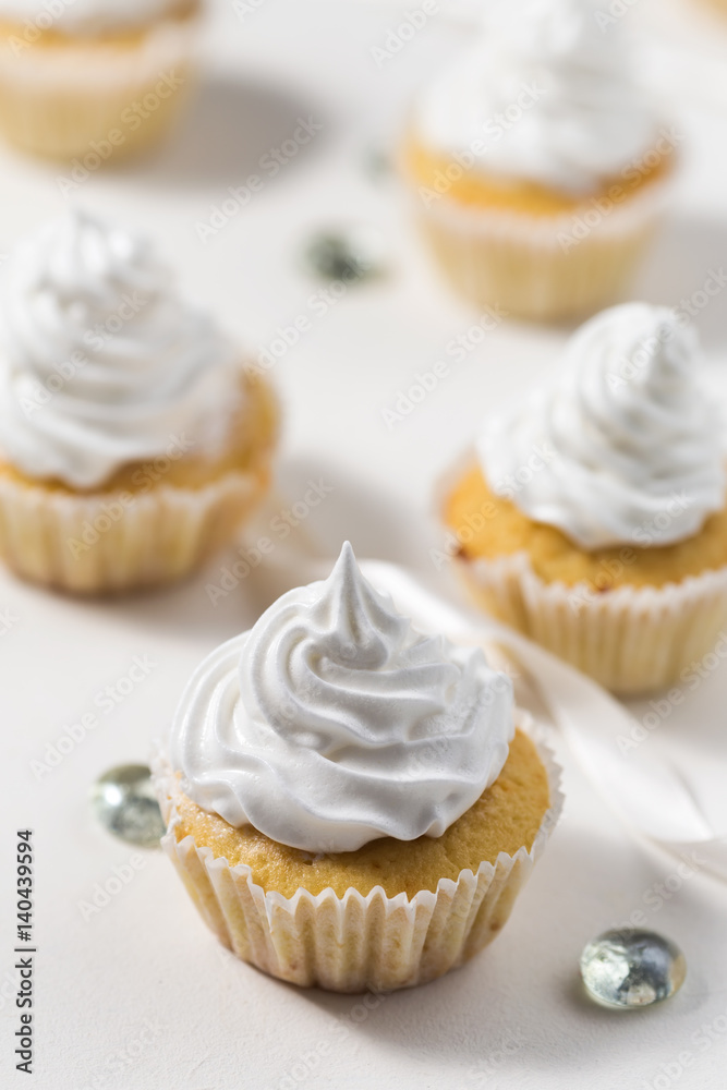 Vanilla cupcakes white white whipped cream on a white table