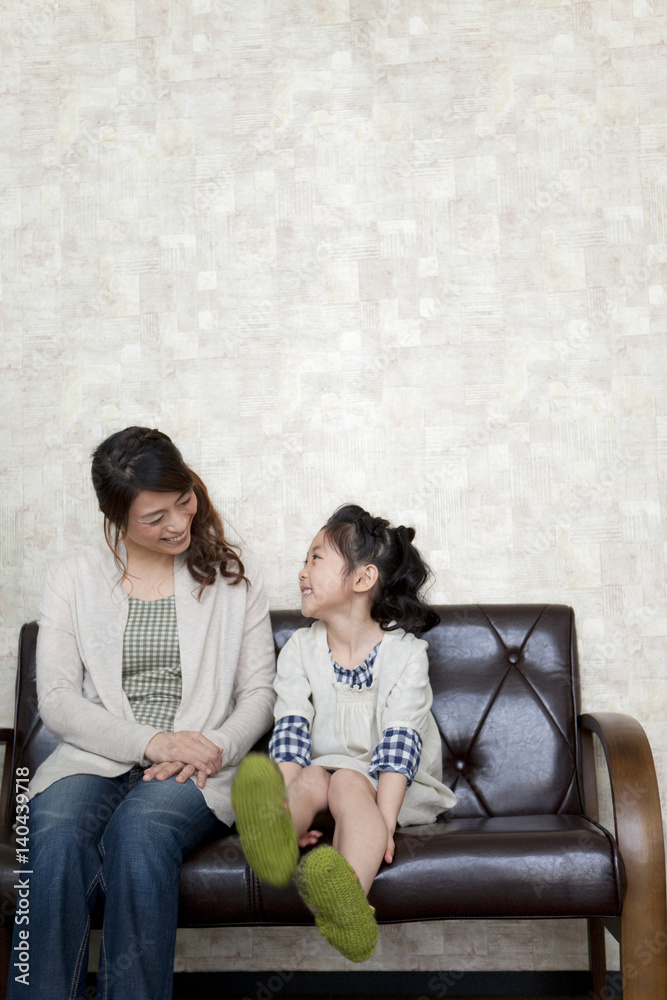 Mother and daughter sitting on sofa Mother and daughter sitting on sofa