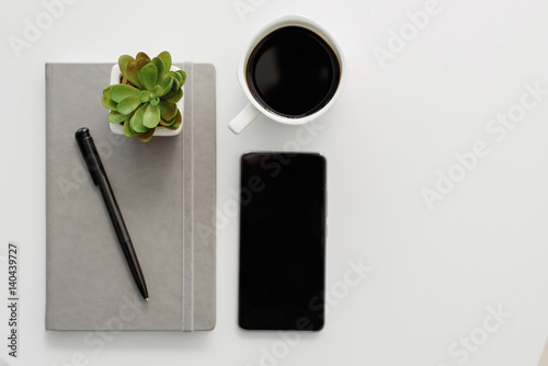 Hot espresso and mobile phone on working desk