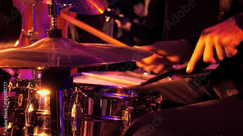 Foto Drummer plays on drum set and cymbal with drumsticks on the stage