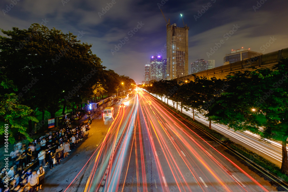 Cityscape of light trails with blurred colors on the street at night.