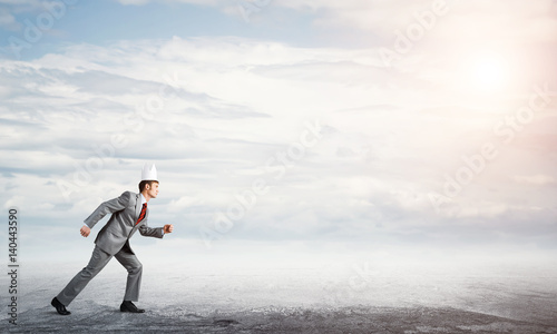 King businessman in elegant suit running and blue sky at background