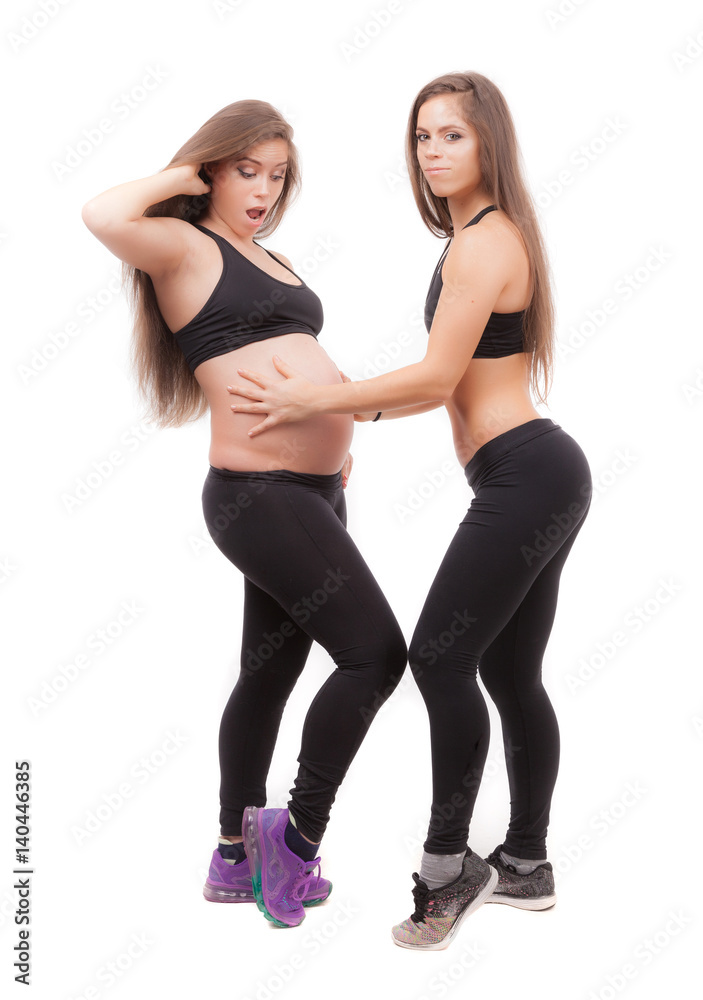 Pregnant woman with her twin sister on a white background.
