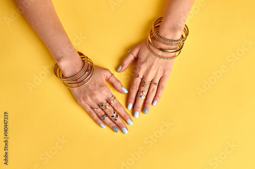Fasion female manicure with gold bijouterie.