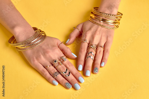 Beautiful female manicure with gold jewelry.