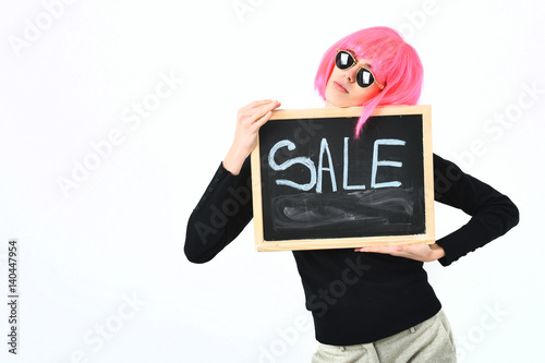 fashionable girl in wig holding board with sale inscription