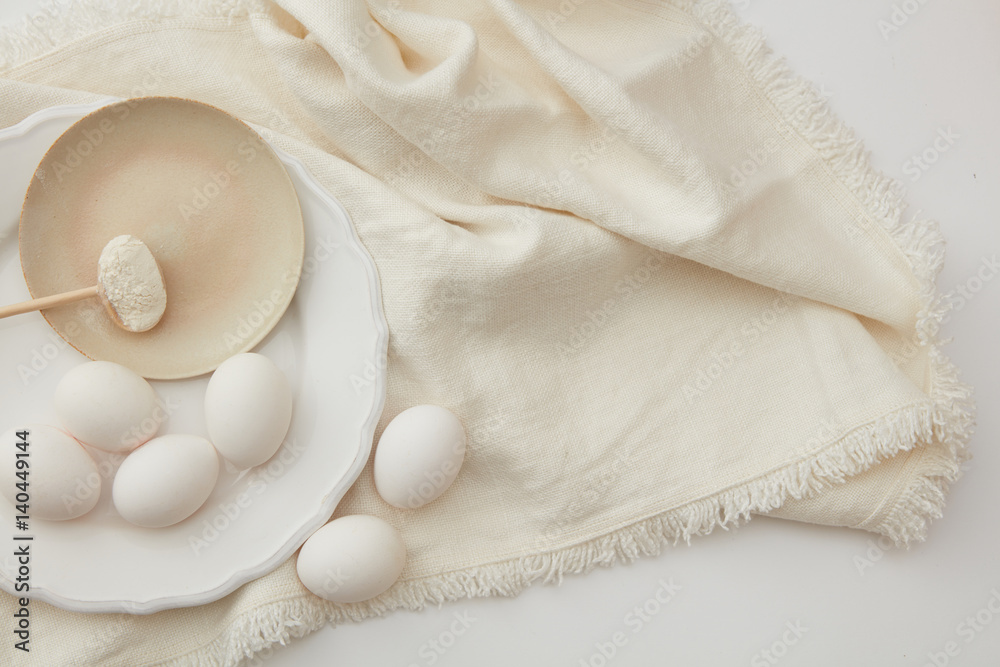 Raw eggs and spoon of flour