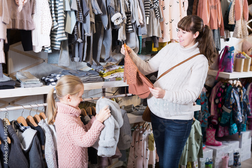 Woman with baby girl choosing clothes