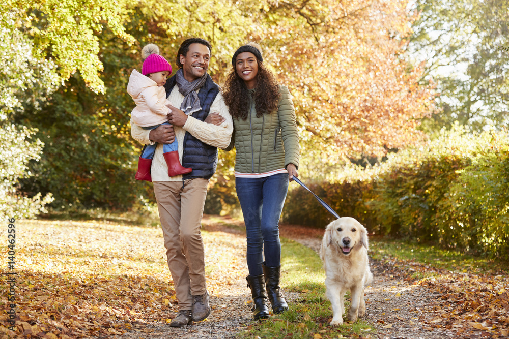 Family With Daughter And Dog Enjoy Autumn Countryside Walk Family With Daughter And Dog Enjoy Autumn Countryside Walk
