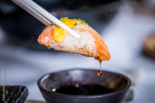 Hands eat sushi with chopsticks