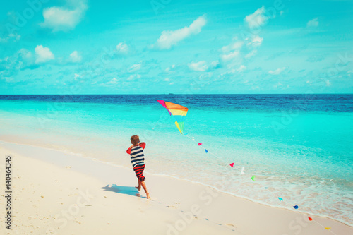 Little boy flying a kite on beach