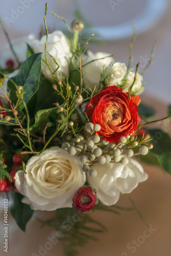 red and ivory floral arrangement prepared for reception  wedding table with candle and setting  winter concept