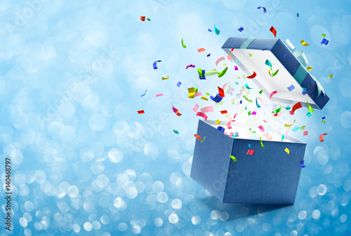 Confetti popping out from blue gift box photo