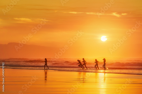 girls having fun in the beach at sunset