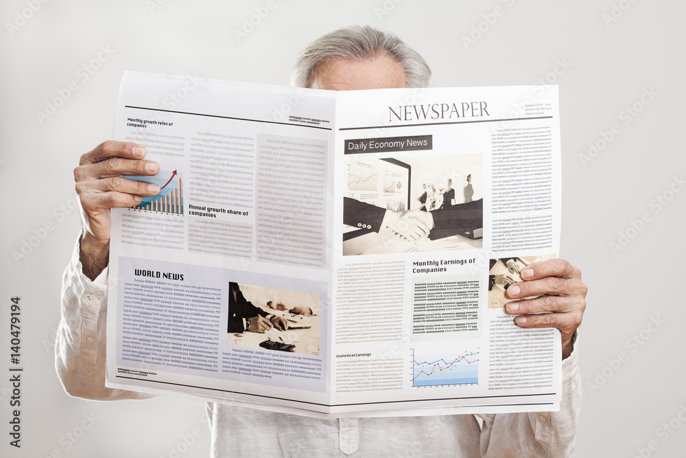 Naklejka premium Portrait elderly man reading newspaper