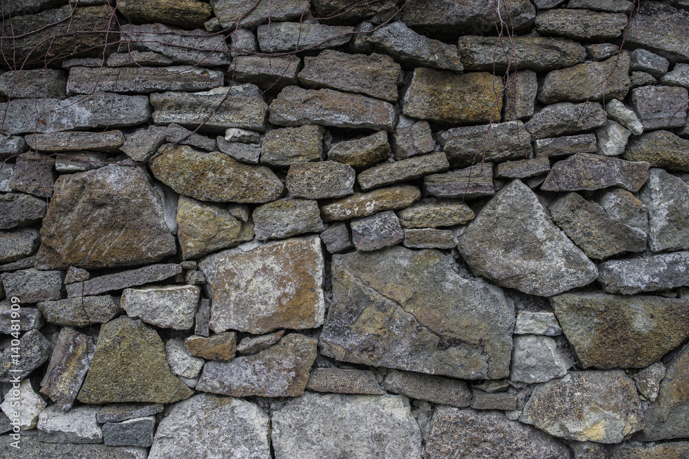 Ancient old dark irregular stone wall