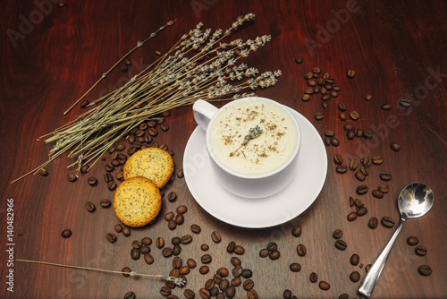 Cup of coffee with milk, pussy-willow and dried branches and leaves at brown background. photo