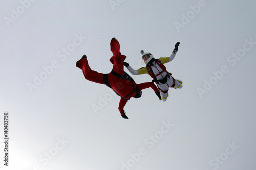Man and woman skydivers are flying in the sky.