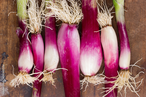 Red onions on wooden background
