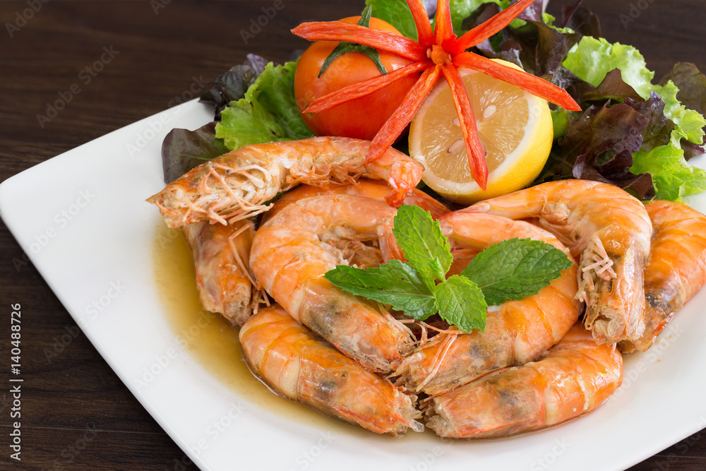 Shrimp boiled with honey and salt in white dish on dark table Shrimp boiled with honey and salt in white dish on dark table