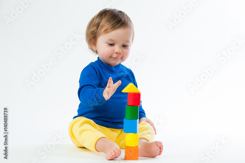 Little child playing with dices isolated on white background