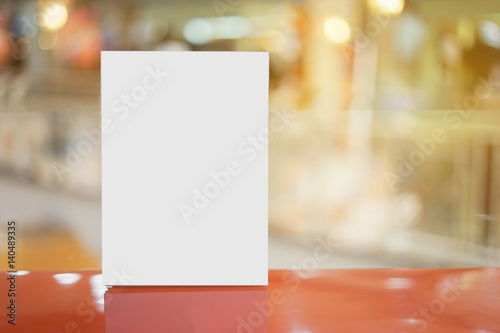 Mock up Menu frame on Table in Bar restaurant cafe,Stand for booklets with white sheets of paper acrylic table tent card mockup on wooden table on cafe teria ,can be used for montage or display photo