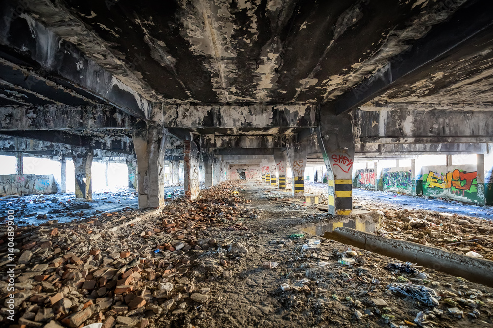 Abandoned building covered in soot and graffiti with ruble and garbage on the floor in an industrial area like a post apocalyptic scene Abandoned building covered in soot and graffiti with ruble and garbage on the floor in an industrial area like a post apocalyptic scene