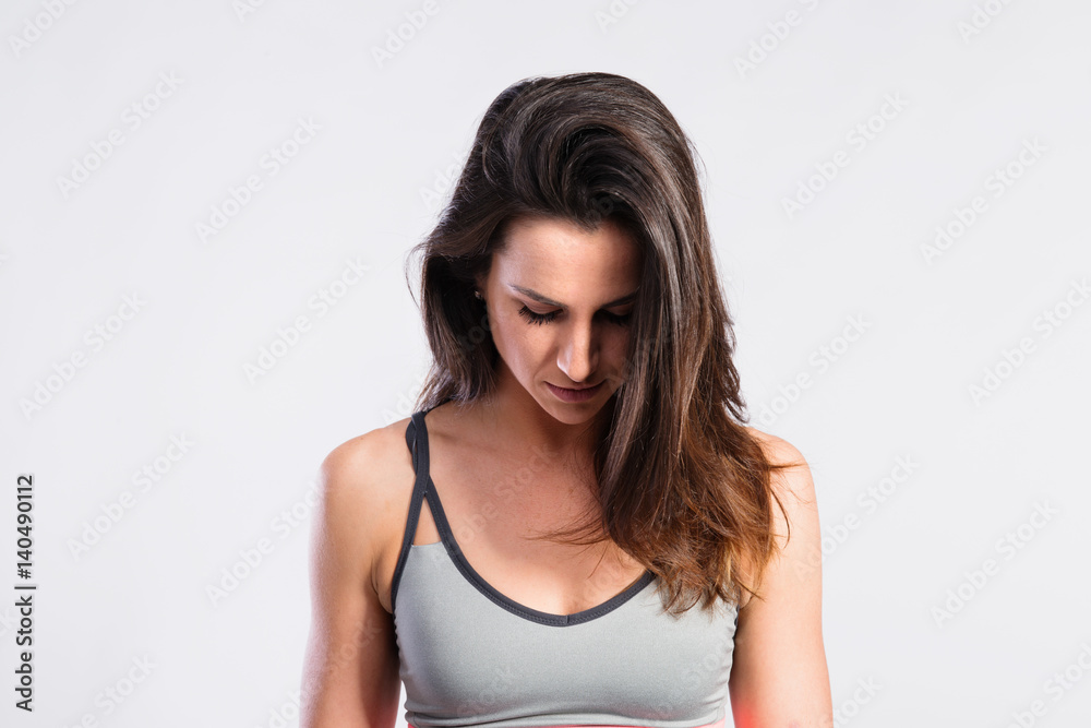 Attractive young fitness woman in gray tank top. Studio shot. Attractive young fitness woman in gray tank top. Studio shot.