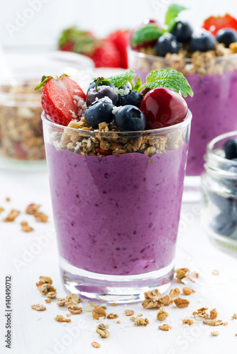 Blueberry dessert with fresh berries and granola on a white background, closeup vertical