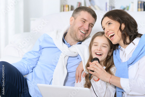 Family with daughter singing karaoke