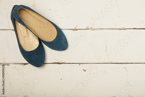 Blue women's shoes (ballerinas) on wooden background.