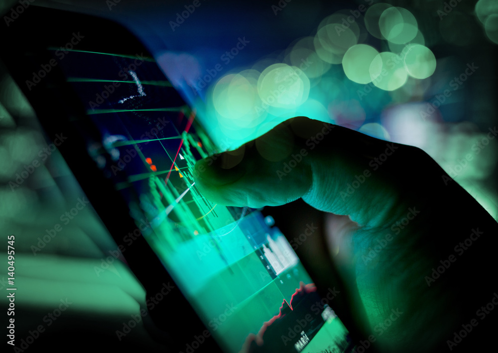 A businessman checking stock charts on a mobile device. Technology and work on the go. A businessman checking stock charts on a mobile device. Technology and work on the go.
