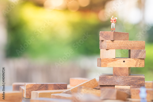 Miniature people : travelers with backpack standing on the top of cactus. Hiking, tourism, exploring the world background concept.