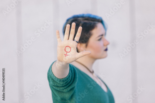 symbol of woman feminism isolated on a hand of a teenager photo
