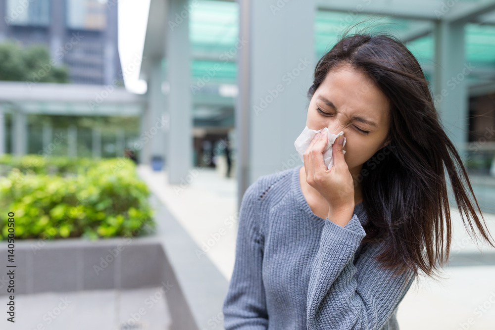 Woman feeling sick and sneezing