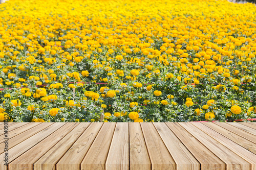 wooden table with yellow marigold flower background