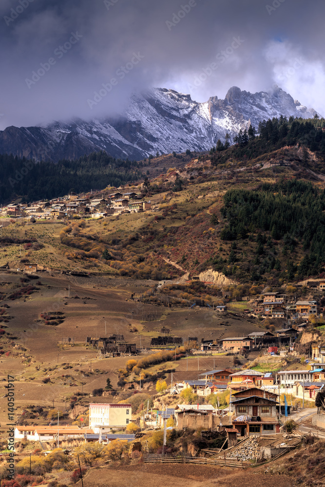 Snow-capped mountain and village in Zhagana, Gansu province of China