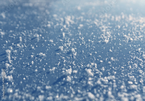 Snow flackes on metal car surface with blur effect. © pavelalexeev