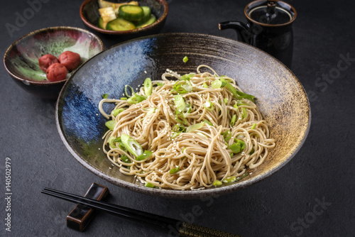 Traditional Japanese Soba Noodles with Tsukemono as close-up in a bowl photo