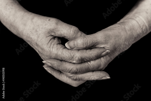 Close up of a pensioner's hands clasped. Monochrome.