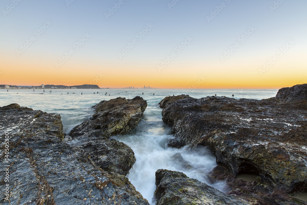 Currumbin Rock Gold Coast clear sky sunrise with incoming ocean rushing through the rocks