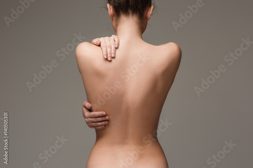 Tableau sur toile The beautiful woman's body on gray background