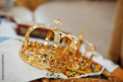 Golden wedding crowns at church ceremony.
