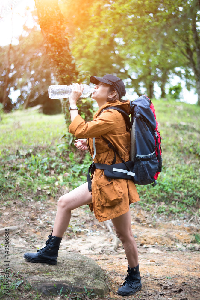 Hiker woman resting drinking water, select focus..